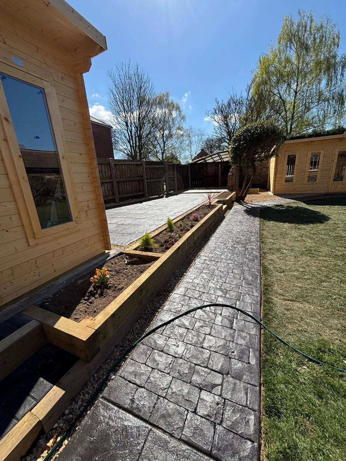 Pattern-imprinted concrete driveway in March by Urban Planet Construction